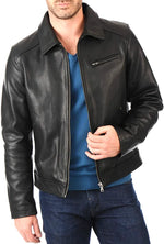 Man wearing a black leather jacket over a blue shirt on a white background