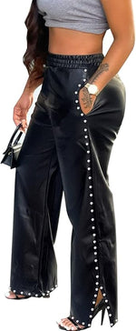 Black pants with pearl embellishments worn by a person.