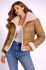 Woman wearing a brown shearling jacket with white fur lining on a white background