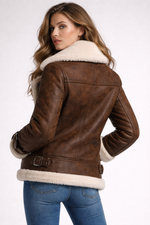 Brown leather jacket with white fur lining worn by a person on a white background